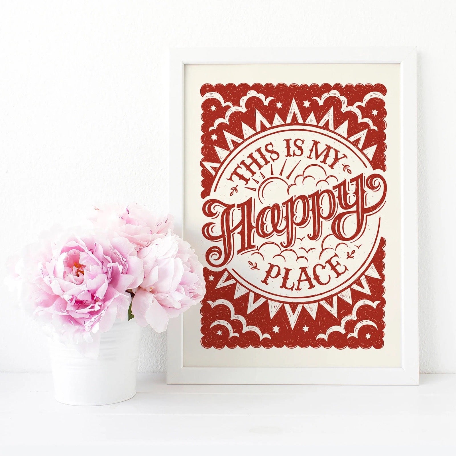 Framed artwork with 'This is my happy place' text next to pink flowers on a white background.