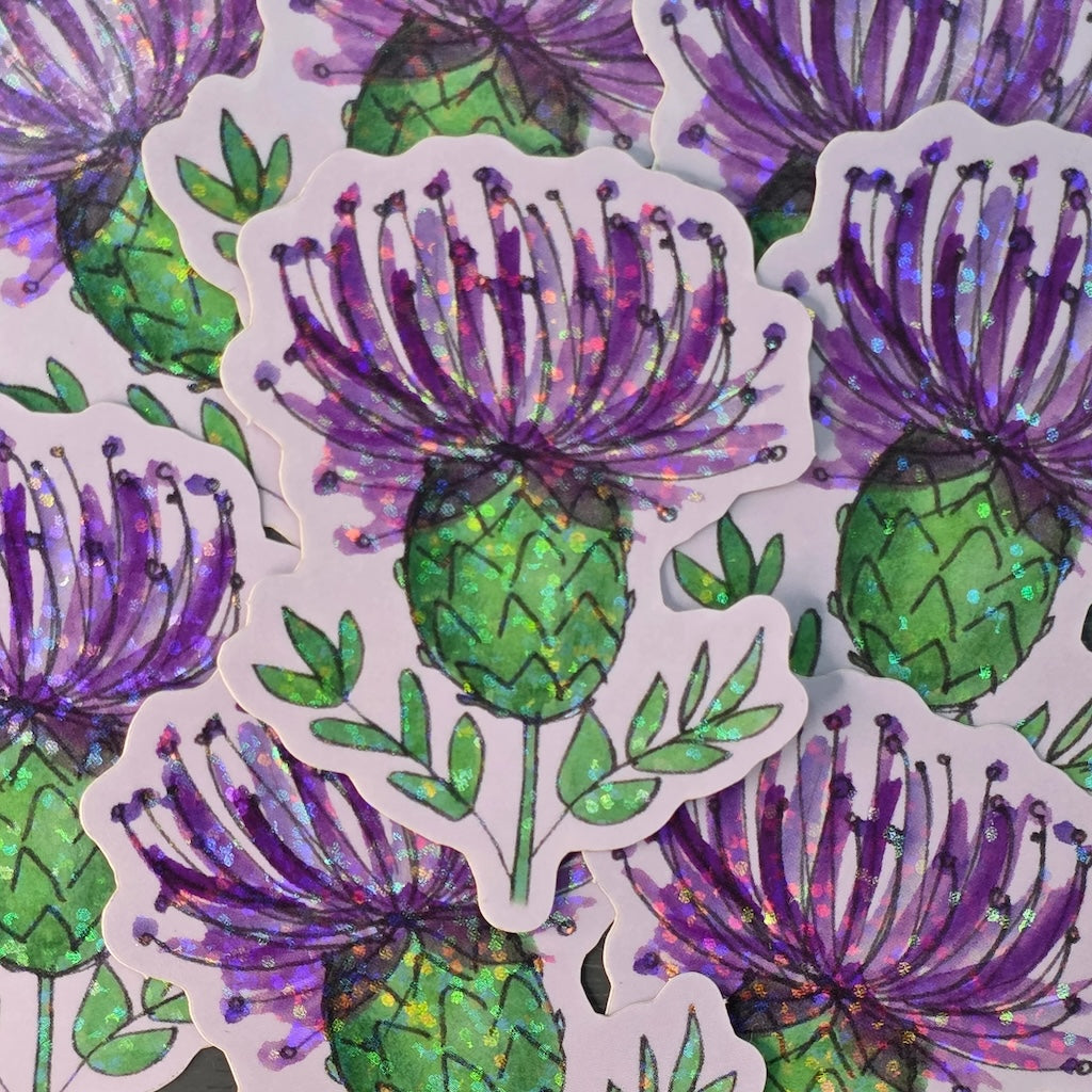 Sticker of a purple thistle flower with green leaves on a white background.