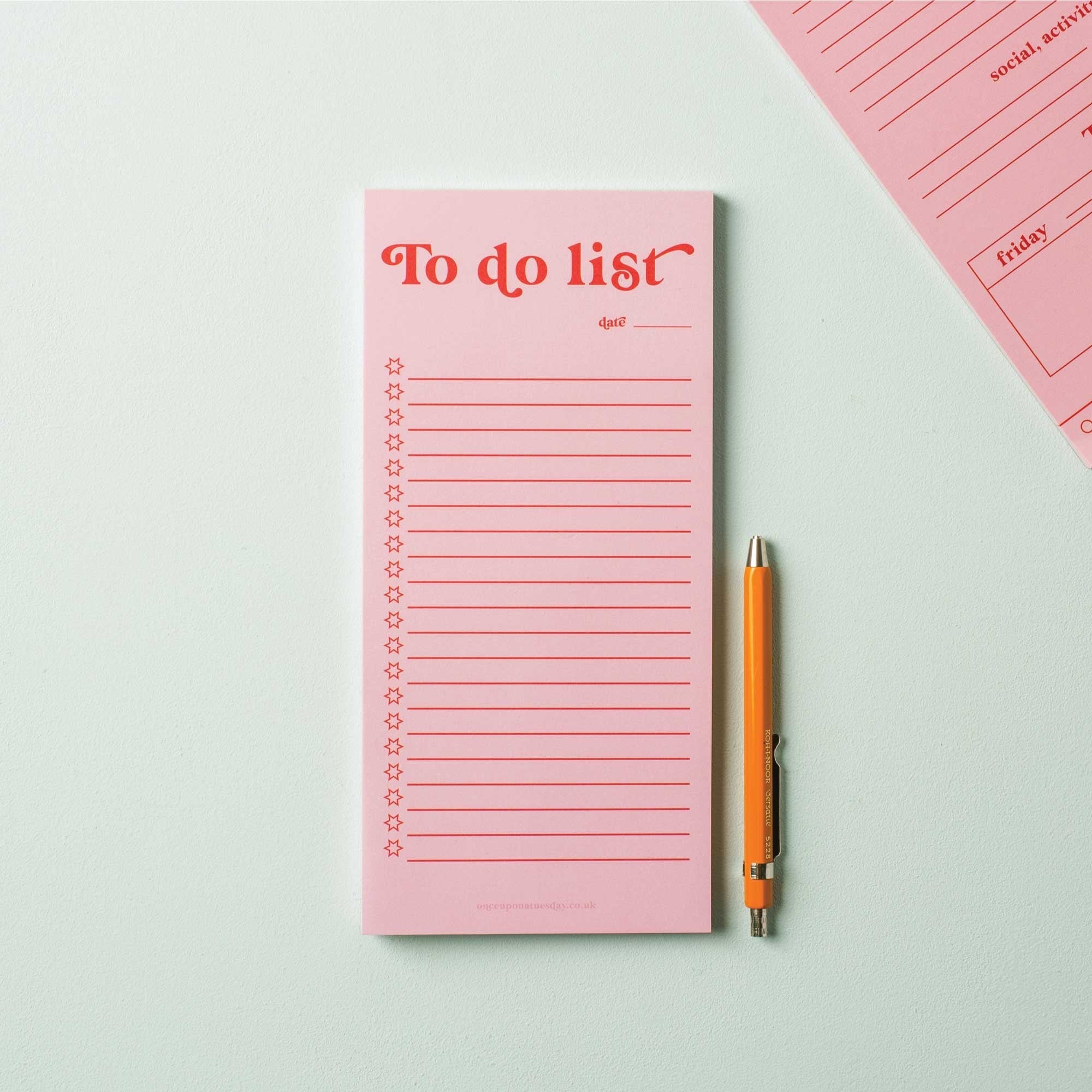 Pink 'To do list' notepad with a pen on a light grey background.