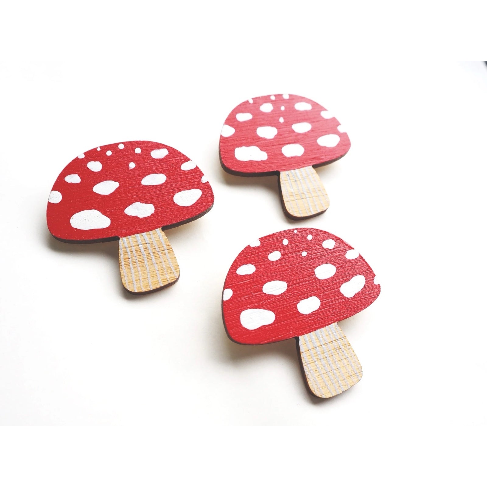 Three toadstool-shaped brooch is made from lightweight and hardwearing bamboo, hand-painted in red and white and sealed with a water-based satin varnish.