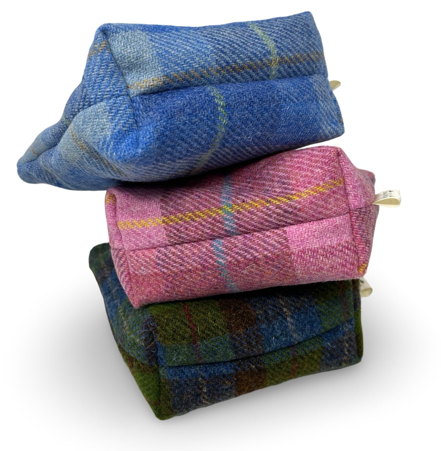 Showing the boxed base of the three colours of Harris tweed toiletry bag.