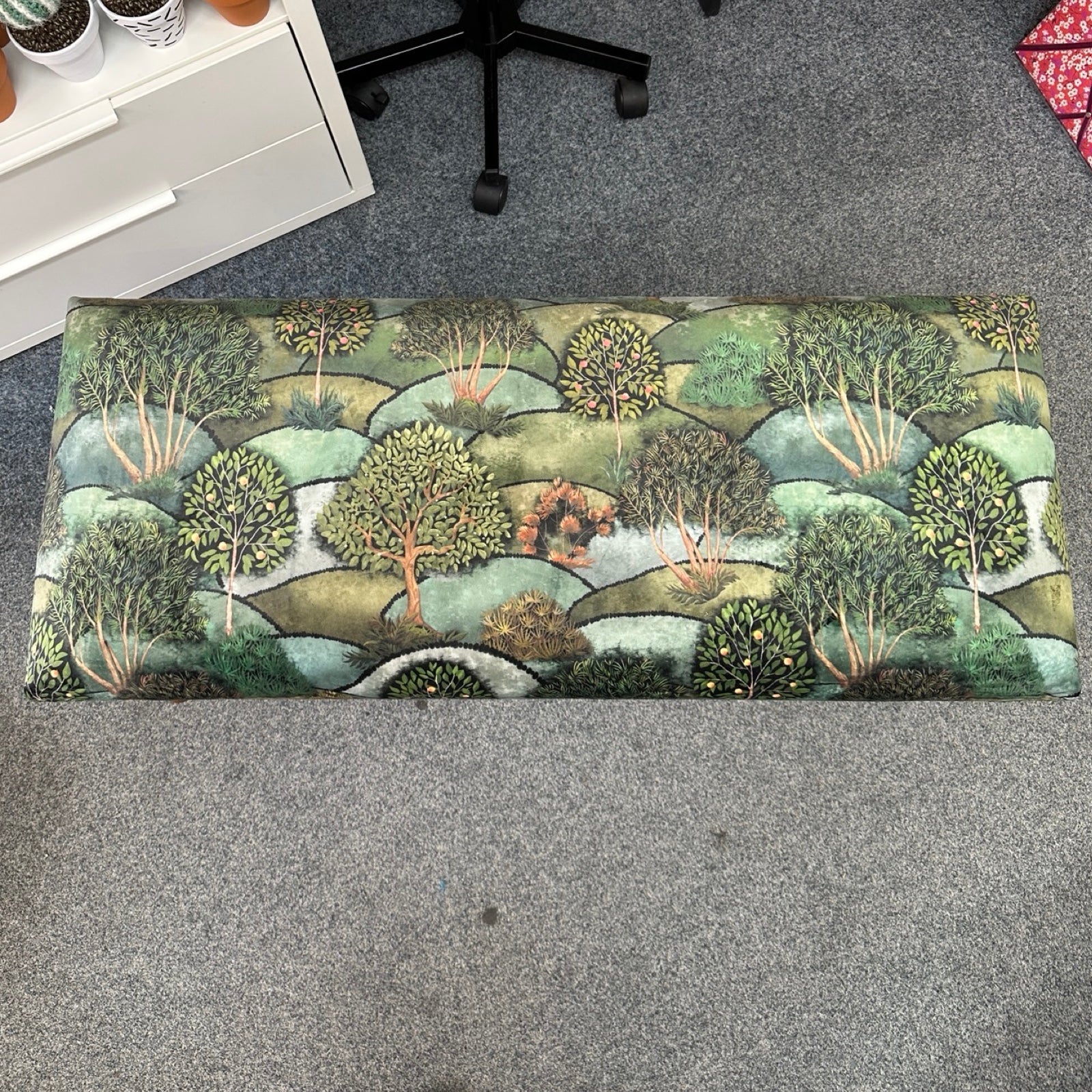 Nature-themed doormat on a gray floor with office furniture in the background.