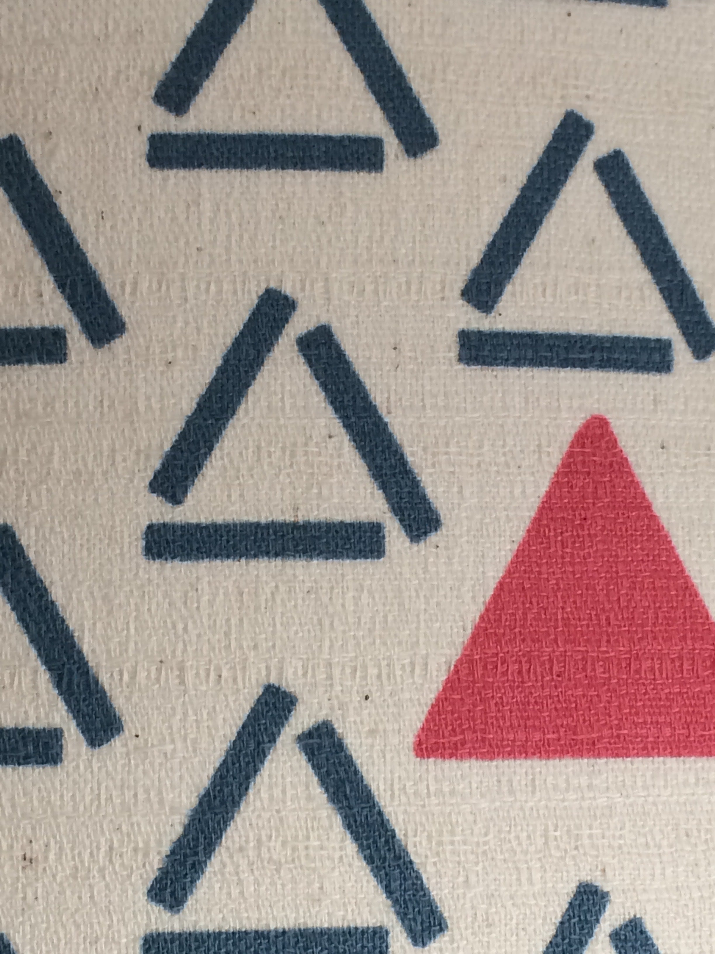 Fabric with a white background, blue open triangles and red closed and filled triangles