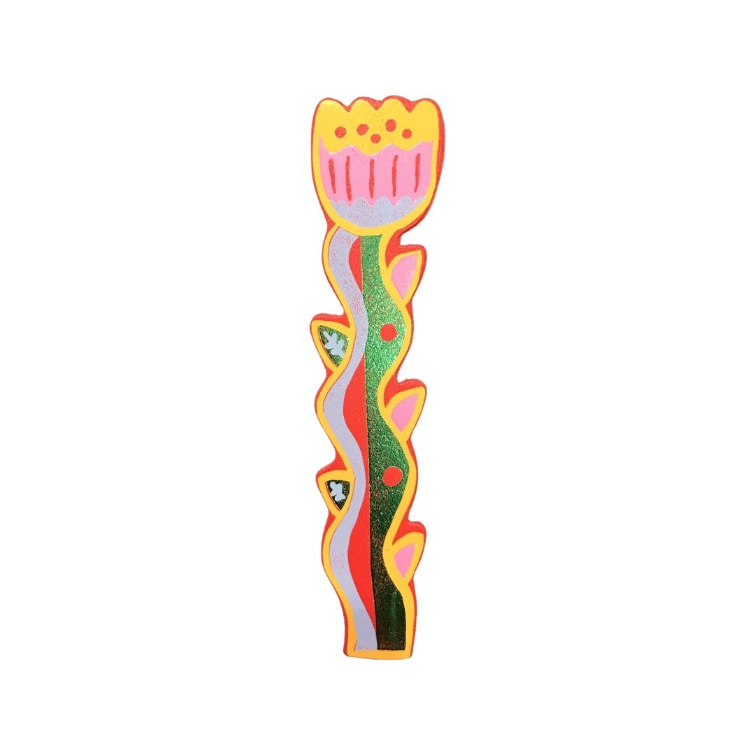 A tulip shaped leather bookmark with a yellow outline, a yellow, pink and lilac flower and a green, red and lilac stem.