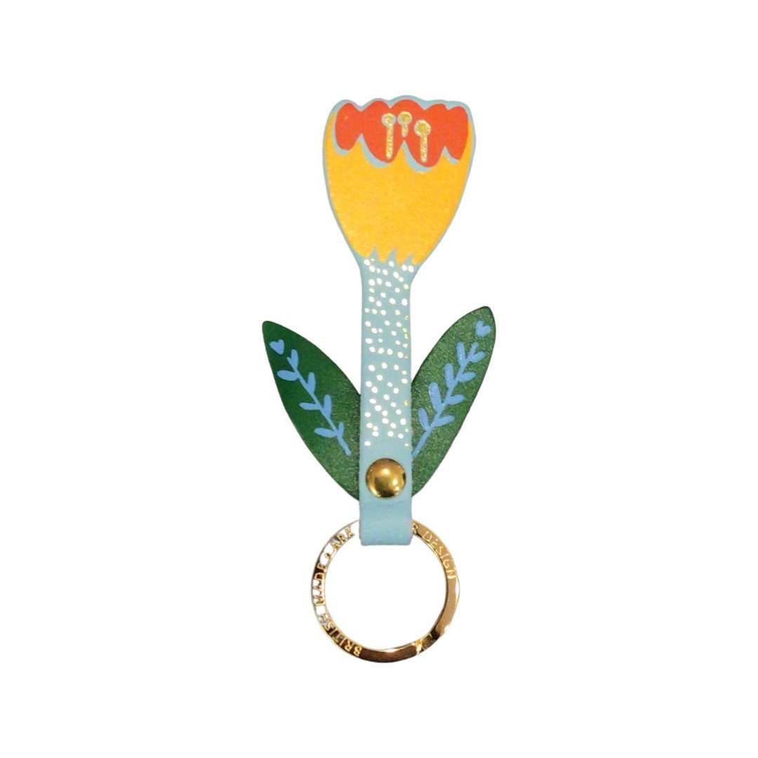 A tulip-shaped leather keyring with a yellow and orange flower, a turquoise stem and green leaves with blue detail on a gold-plated ring.