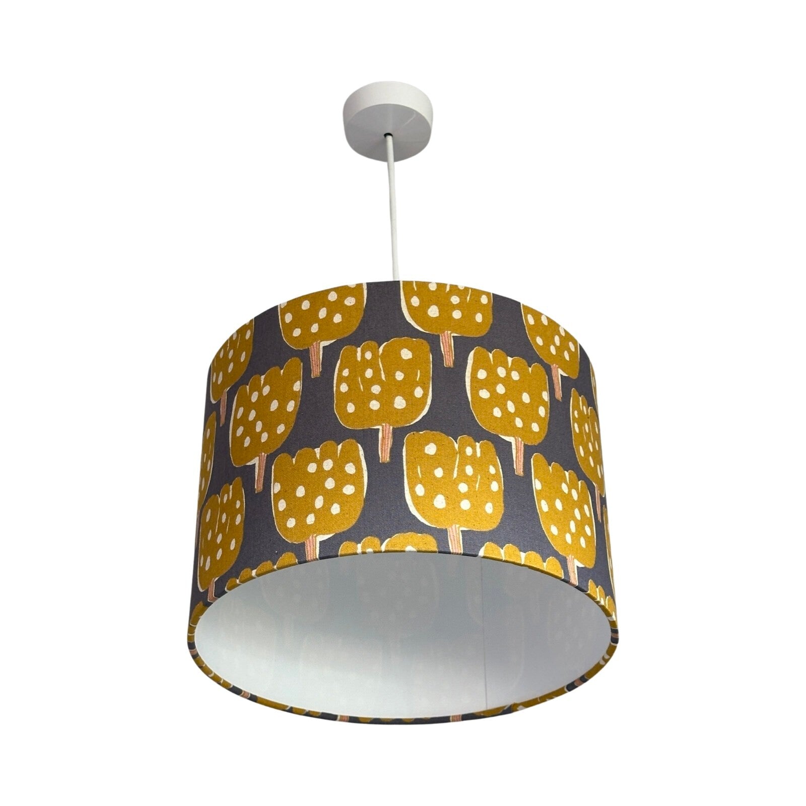 drum lampshade covered in grey canvas fabric with mustard tulip-shaped trees with pale pink tree trunks