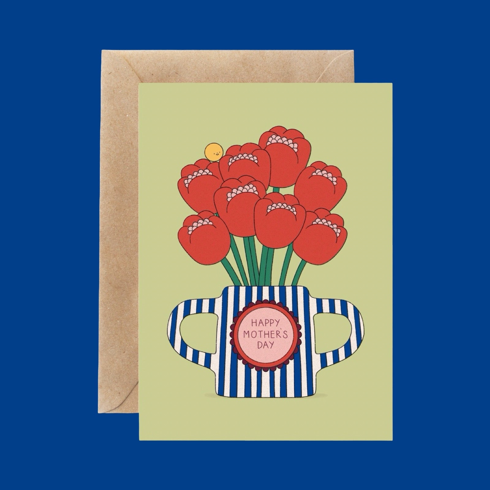 A Mother's Day greeting card featuring red tulips inside a blue-and-white striped vase, shown with a kraft envelope on a solid blue background.