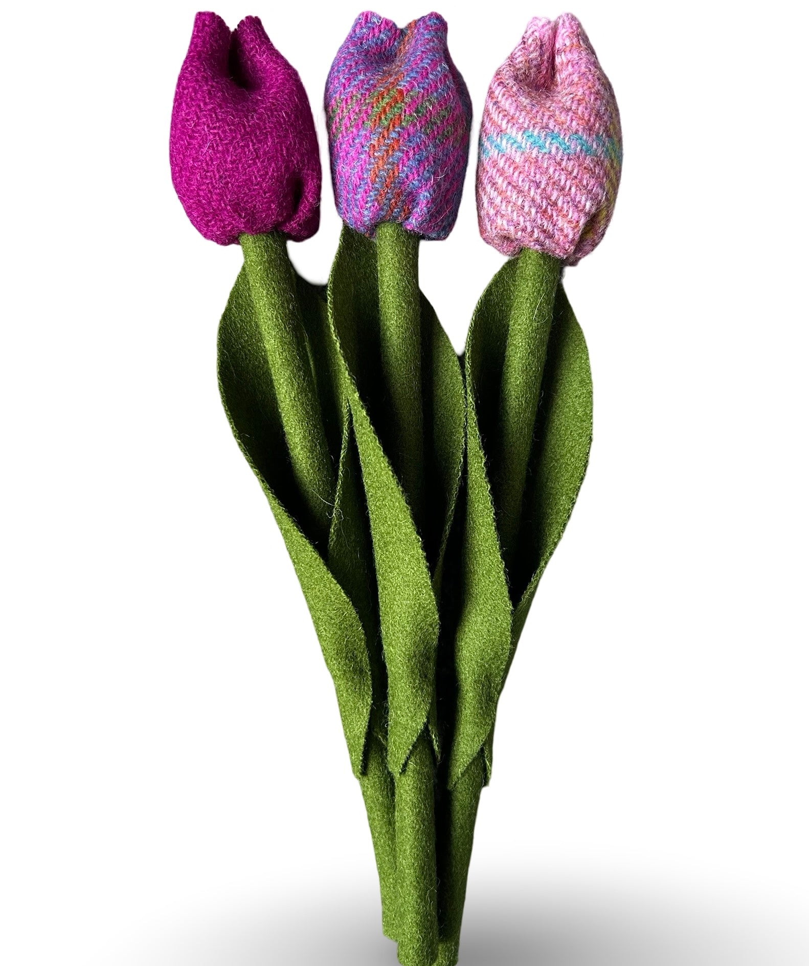 Three tweed tulips with green tweed stems and leaves. One has a pale pink bud, one is fuchsia pink and one is purple.
