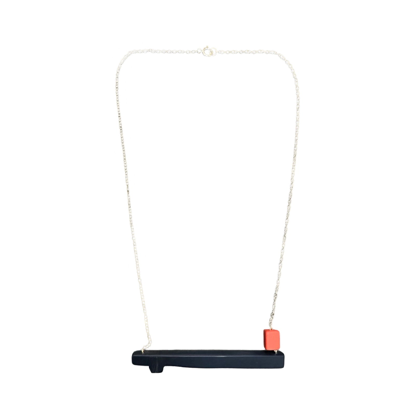 Navy twig shaped necklace with a small coral bead on the right side, hanging from a silver chain.