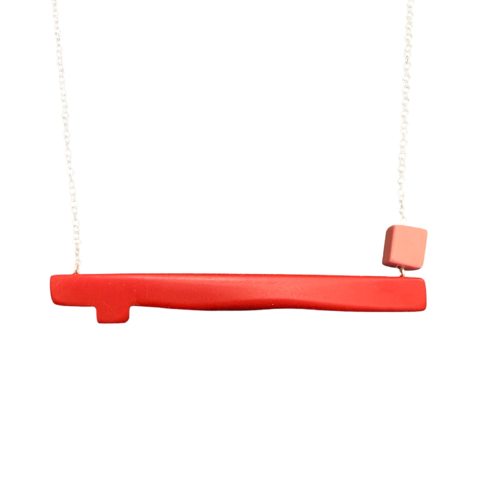 Coral twig shaped necklace with a small pink bead on the right side, hanging from a silver chain.