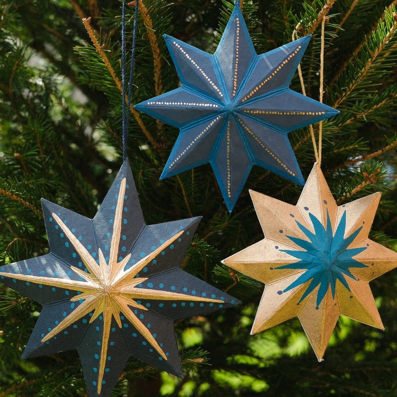 This festive navy, gold and teal star decoration has a matching 10cm cotton loop for hanging. Each star decoration is made from 100% recycled paper, screen-printed by hand and moulded into a durable board decoration.
