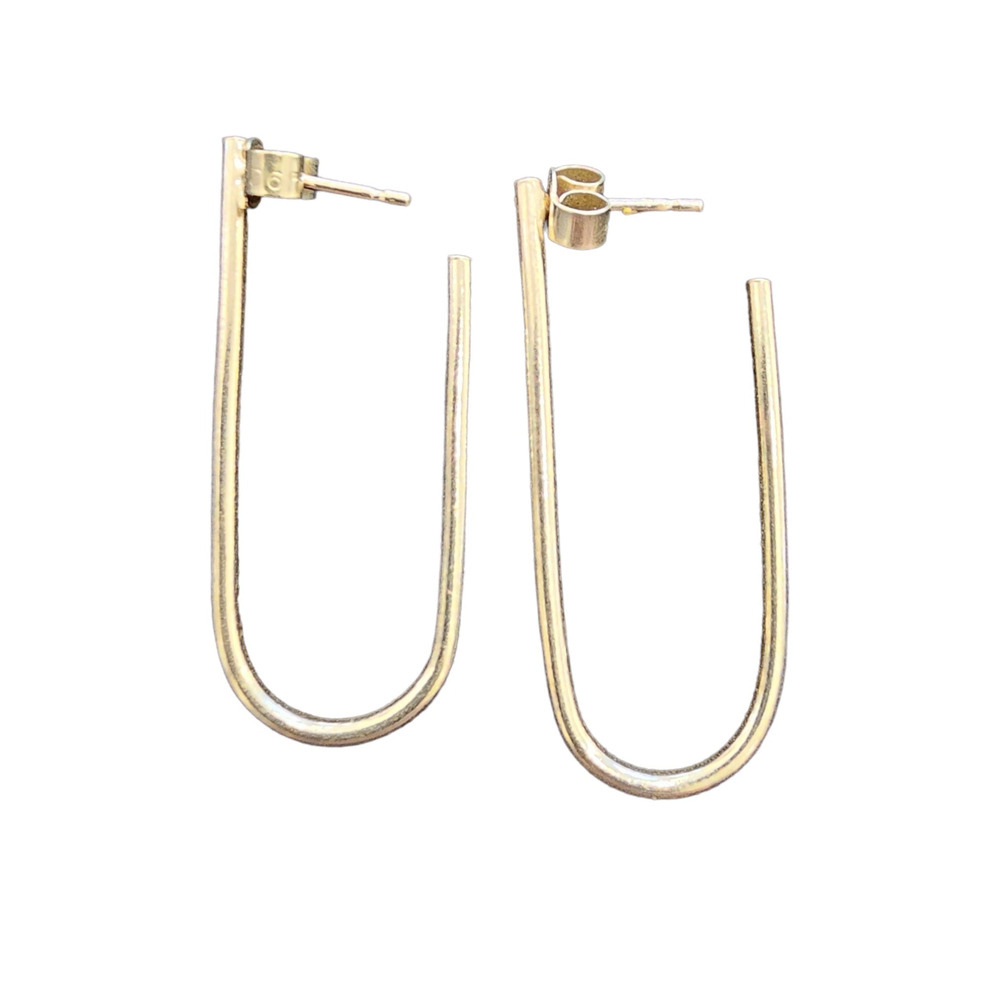 U shaped earrings in gold against a white background.