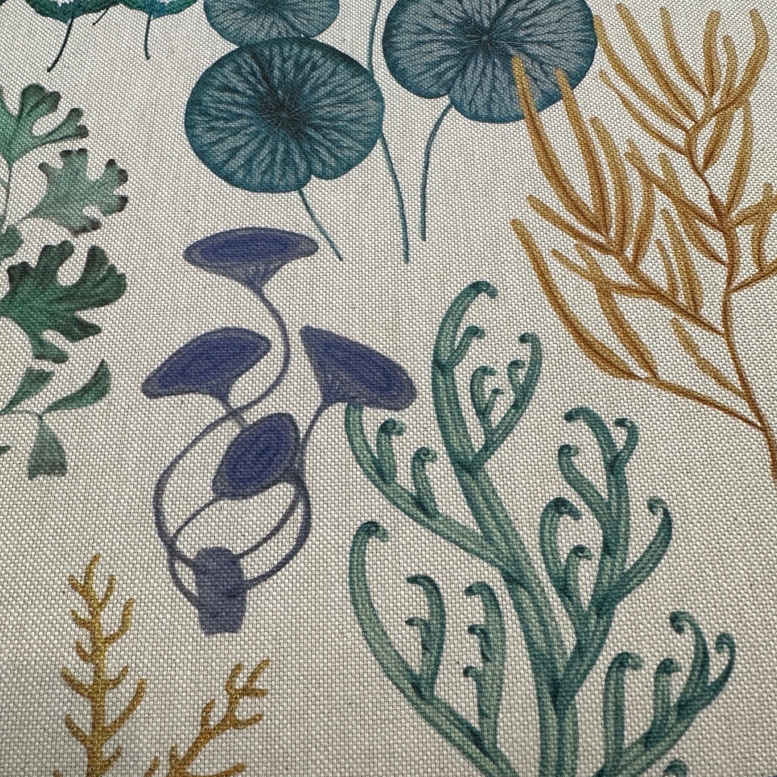 Cotton/linen fabric with underwater designs in green, blue and mustard.