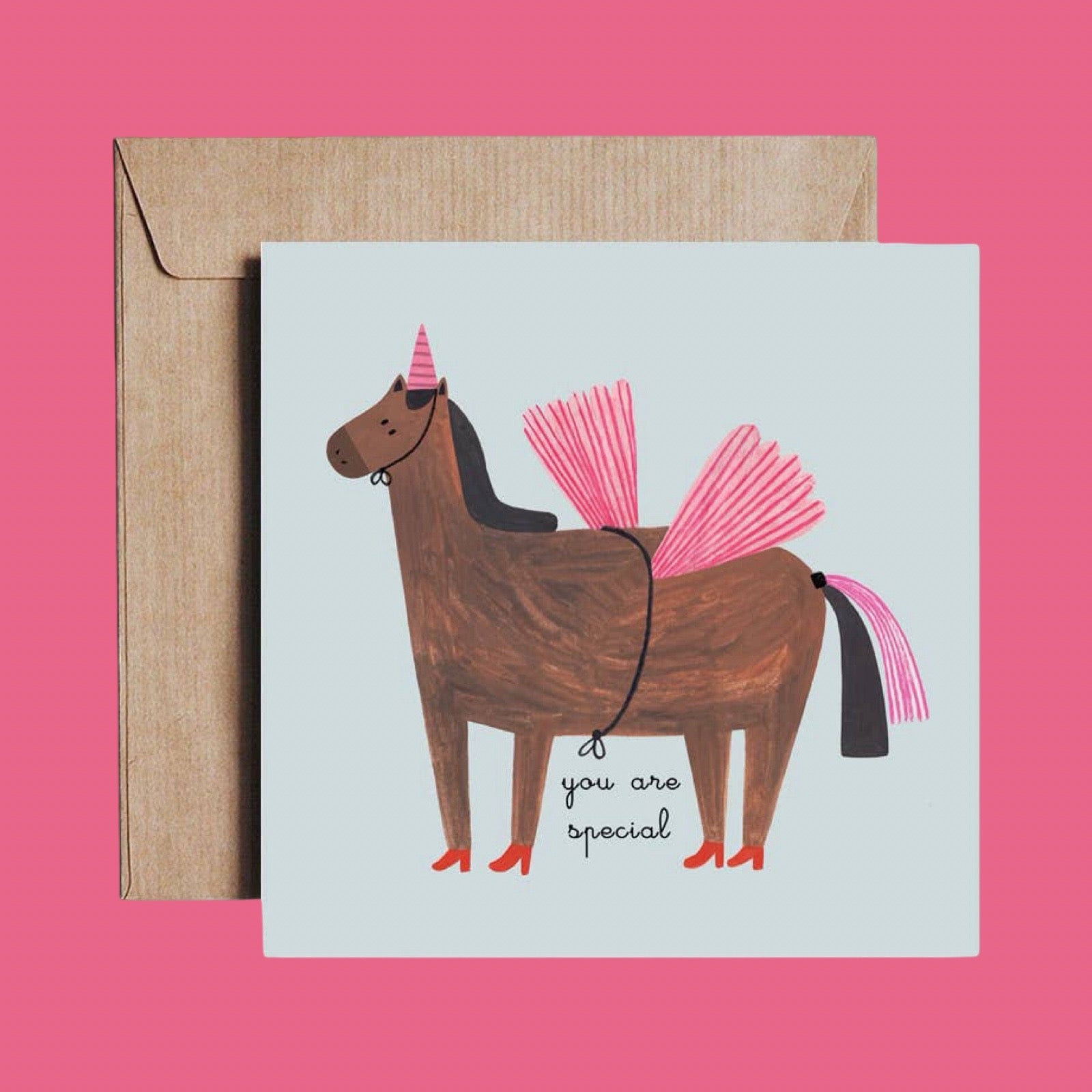 Greeting card with a horse wearing a unicorn costume and 'you are special' text, with a brown envelope, on a pink background.