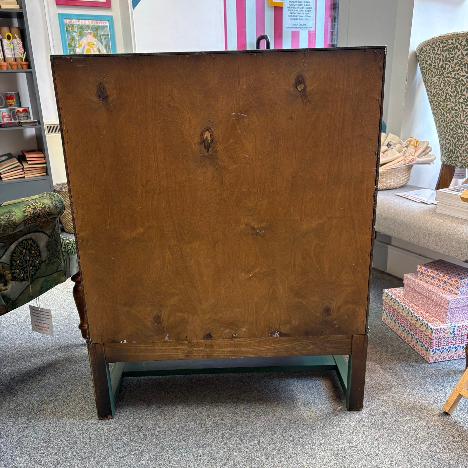 Back view of a wooden cabinet with a blurred indoor setting.
