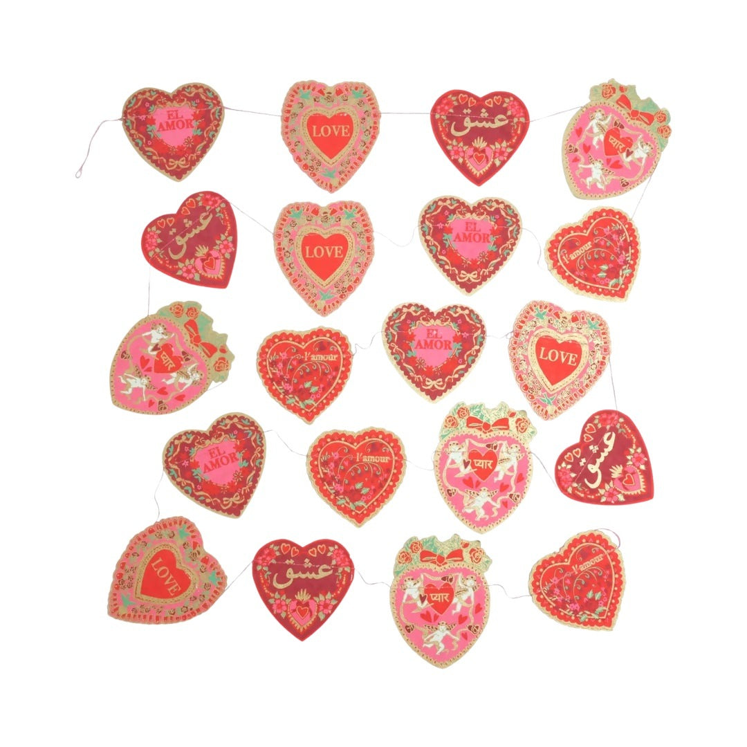 A Valentine's paper garland featuring twenty screen-printed love hearts in reds, pinks and gold. Each heart features the word 'love' in a different language.