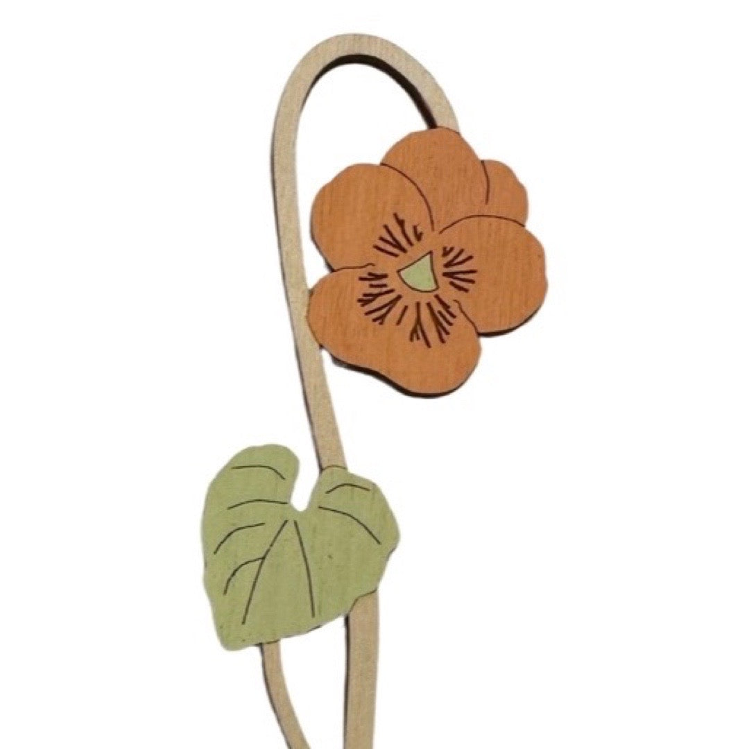 Wooden viola flower with a green leaf on a white background.