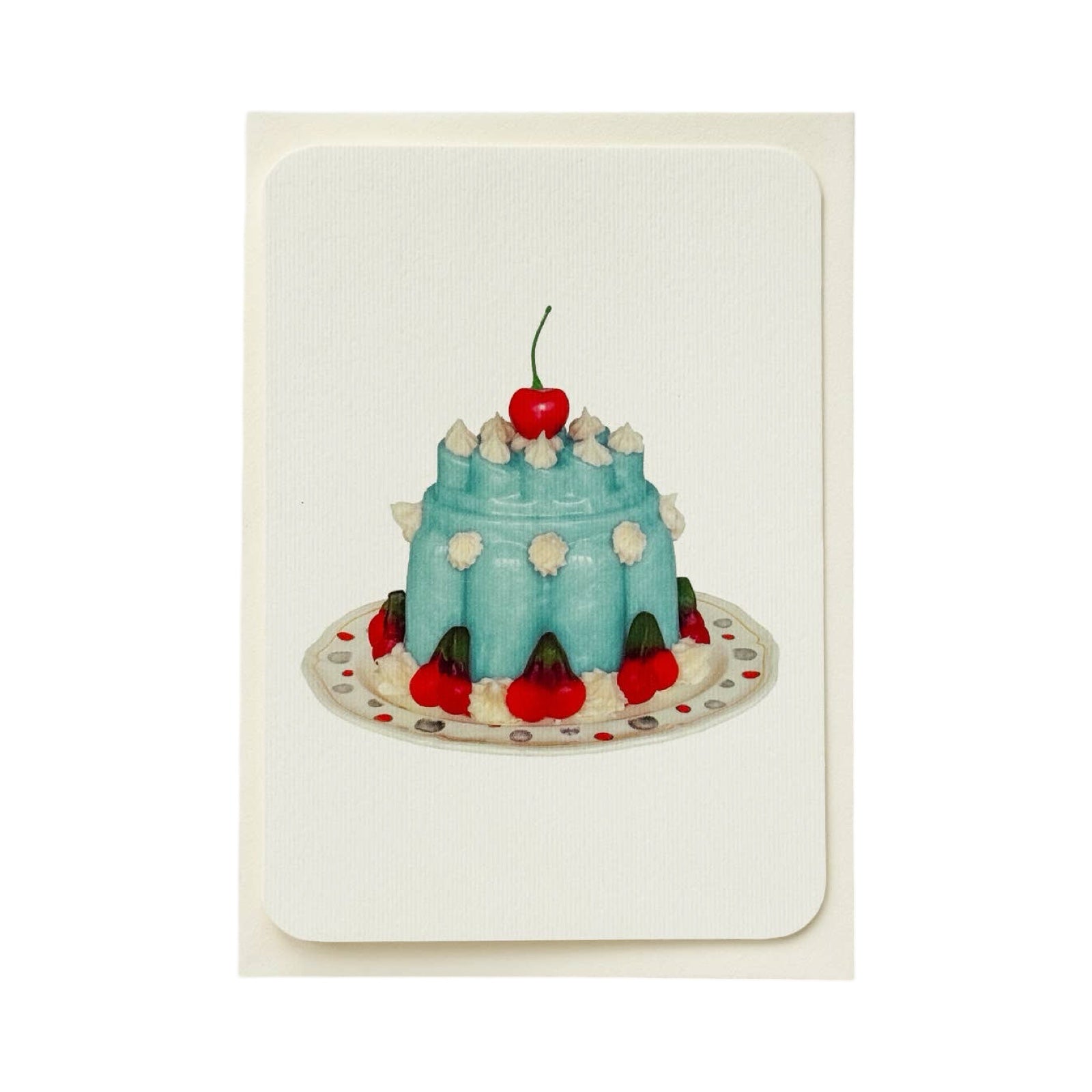 A cream coloured birthday card with a turquoise coloured blancmange with cream and a cherry on the top, all on a white plate.