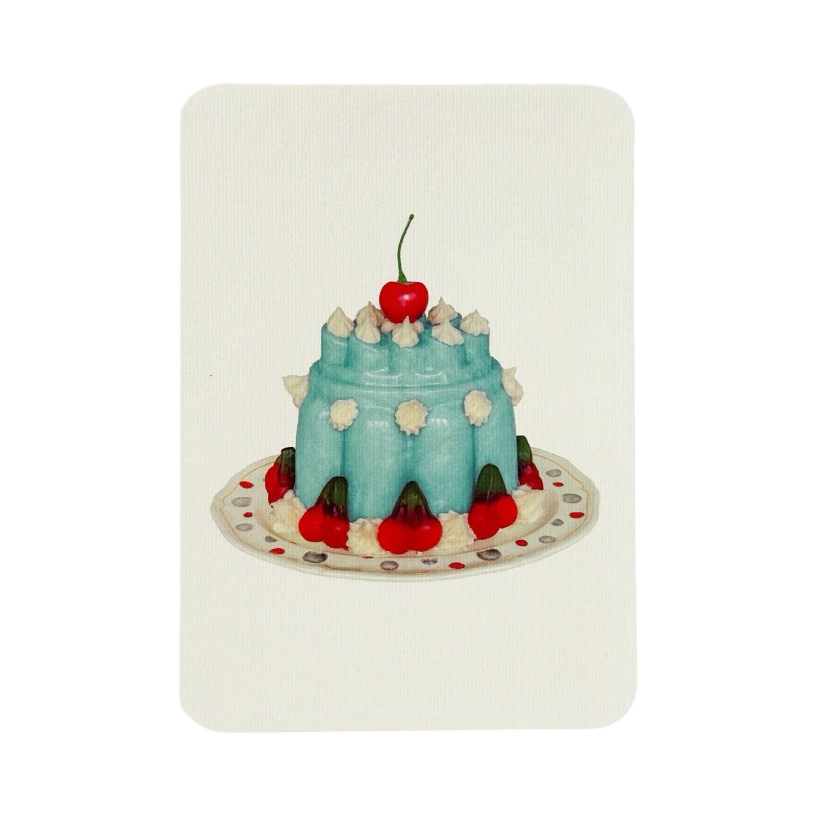 A cream coloured birthday card with a turquoise coloured blancmange with cream and a cherry on the top, all on a white plate.
