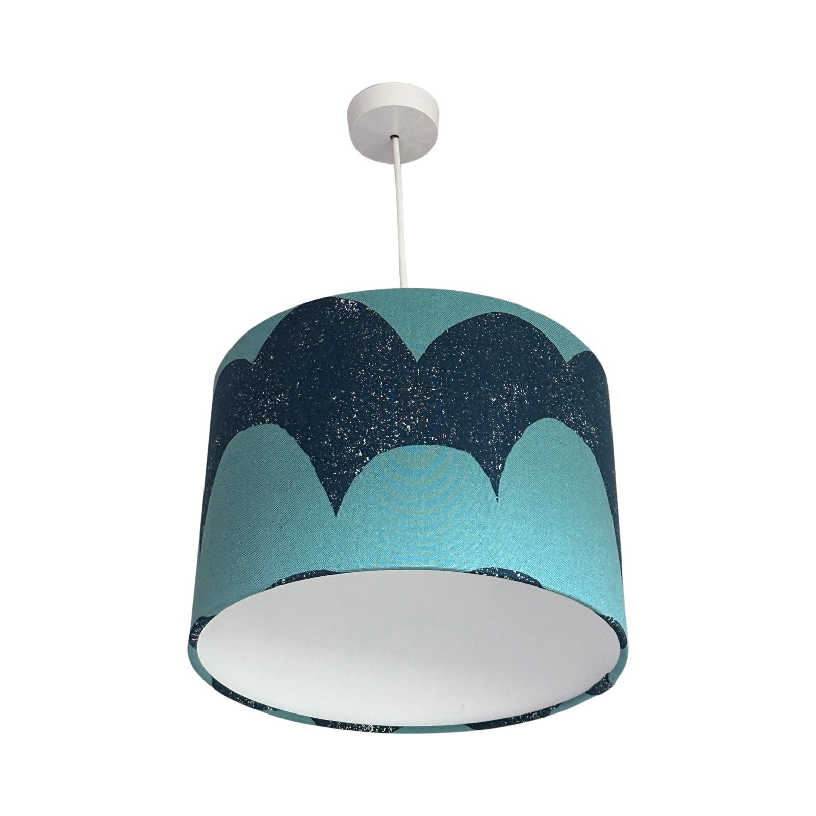 drum lampshade covered in navy and turquoise canvas fabric in a waves pattern.