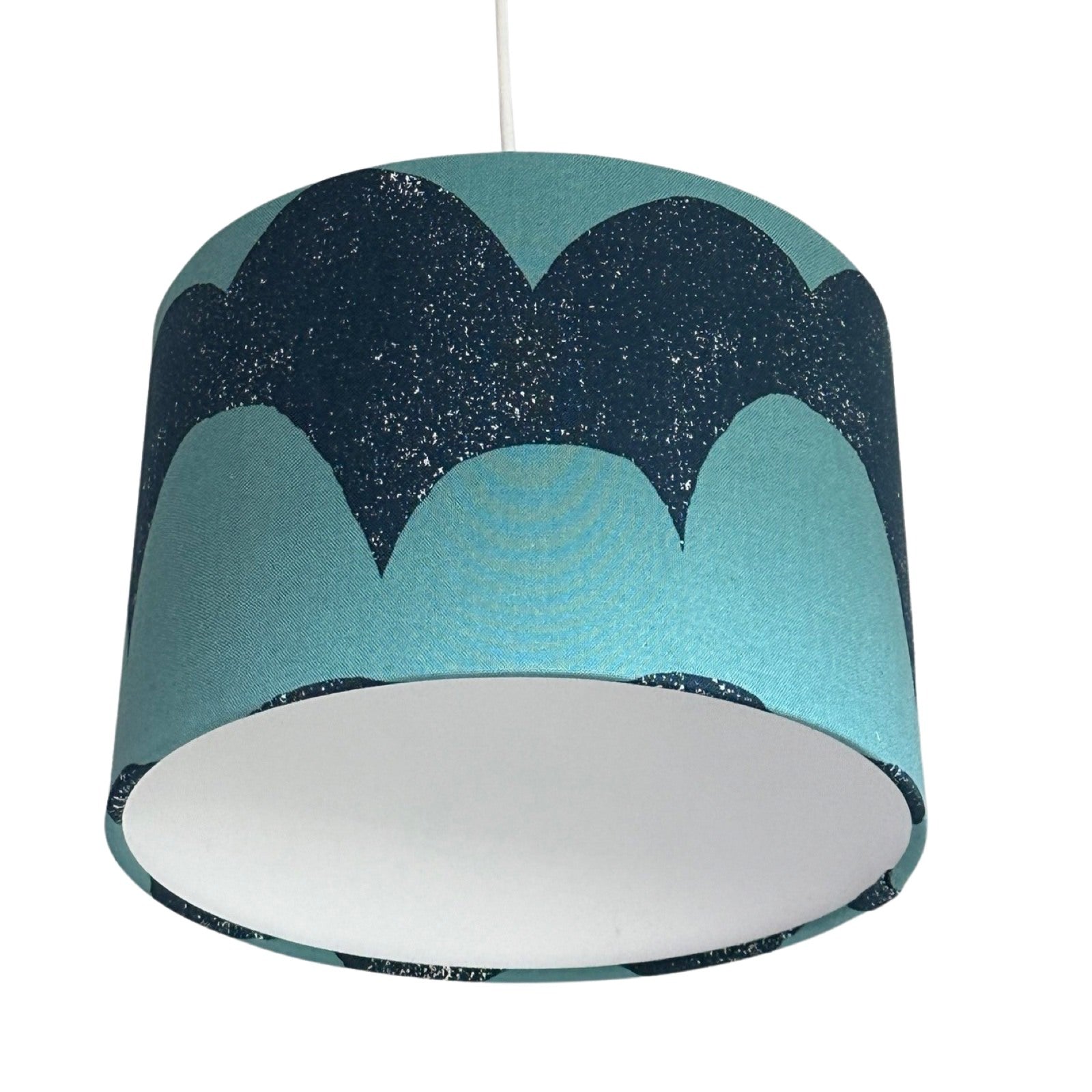 drum lampshade covered in navy and turquoise canvas fabric in a waves pattern.