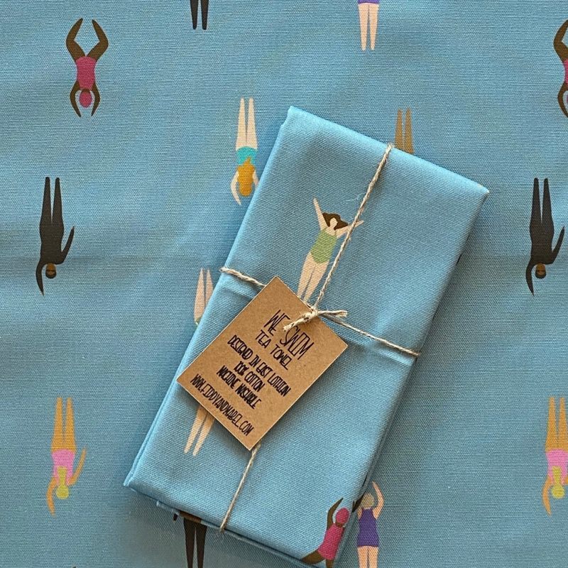 Tea towel featuring a host of wild swimmers in the sea.