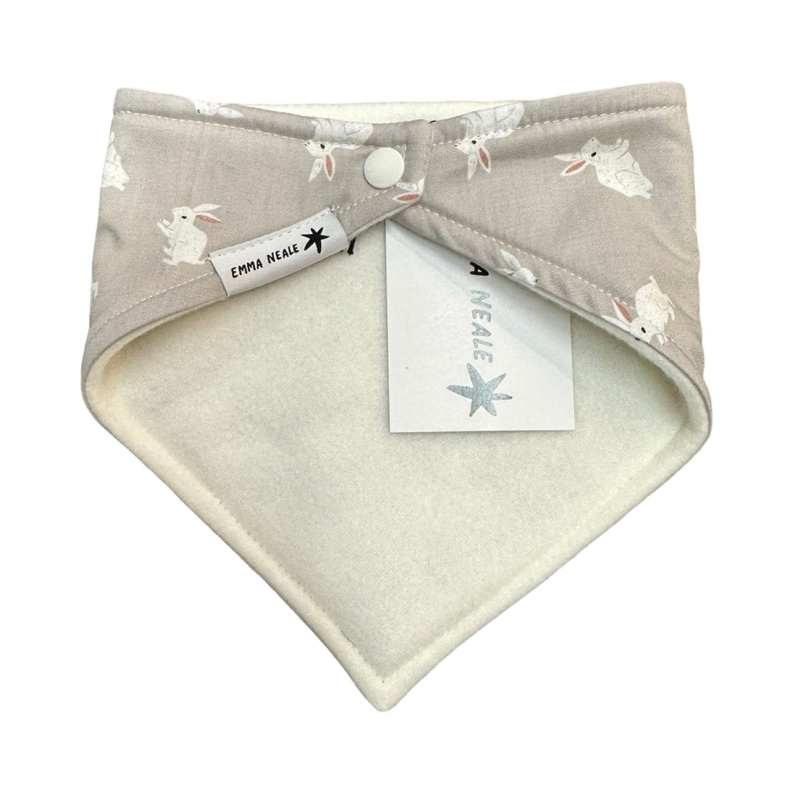 The back of A baby bandana bib in grey cotton fabric with white rabbits and white fleece lining.