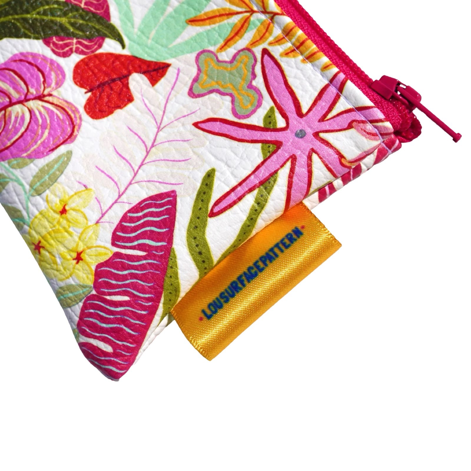 Vegan leather purse with colourful tropical leaves against a white background.