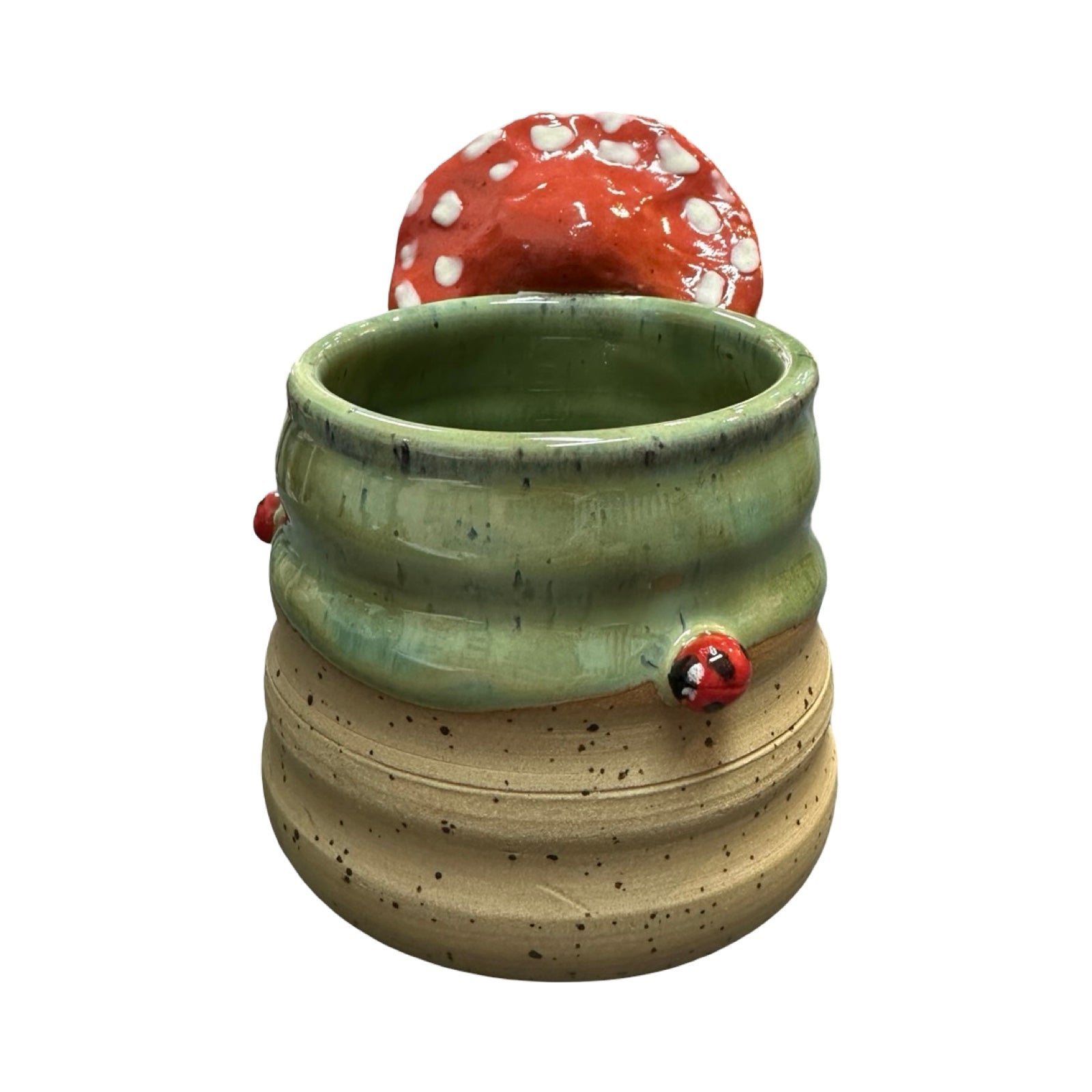 Ceramic mug with a red mushroom and ladybird decorations on a white background.