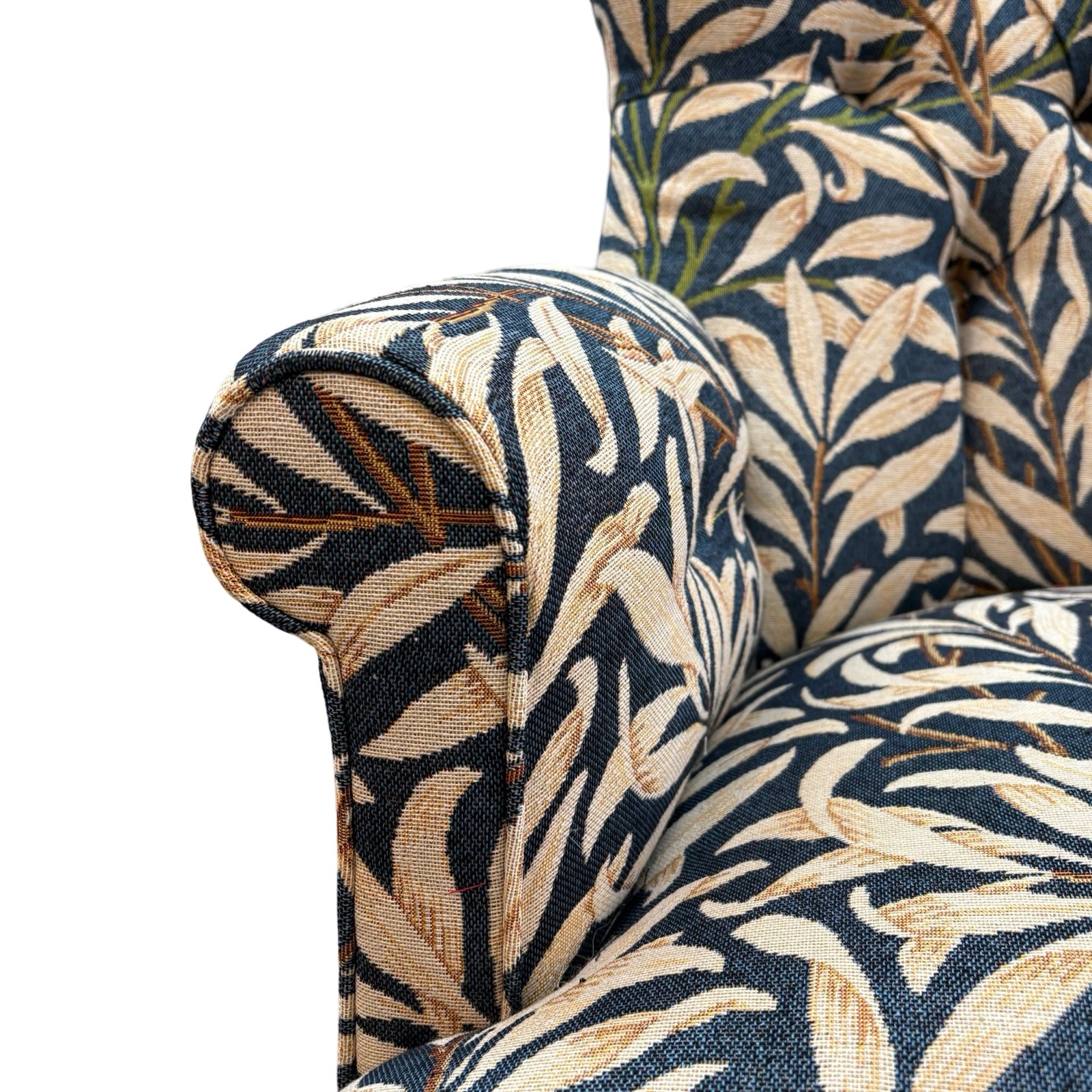 The arm detail of a hand-crafted occasional armchair in blue and cream William Morris Willow Bough tapestry style fabric