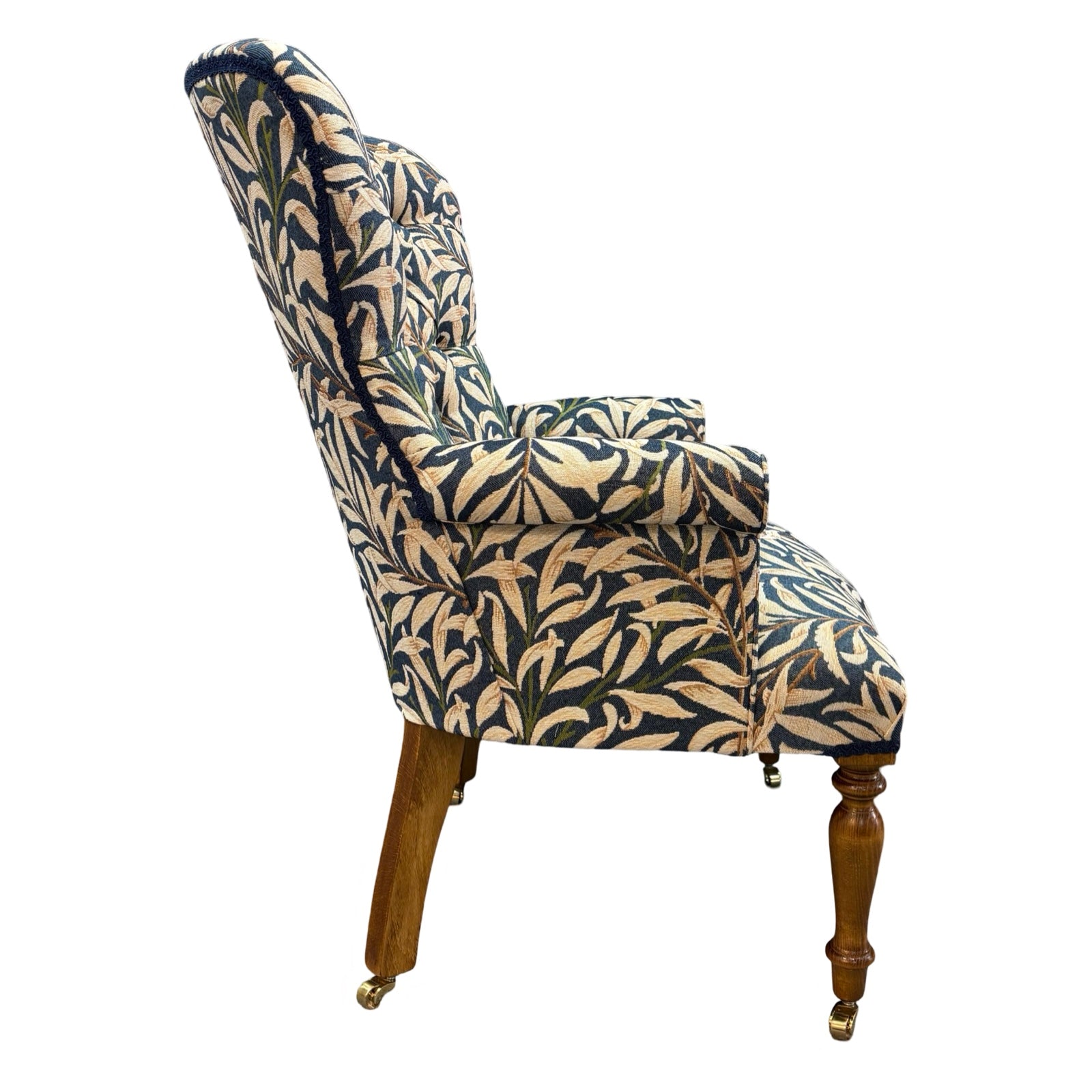 The side of a hand-crafted occasional armchair in blue and cream William Morris Willow Bough tapestry style fabric