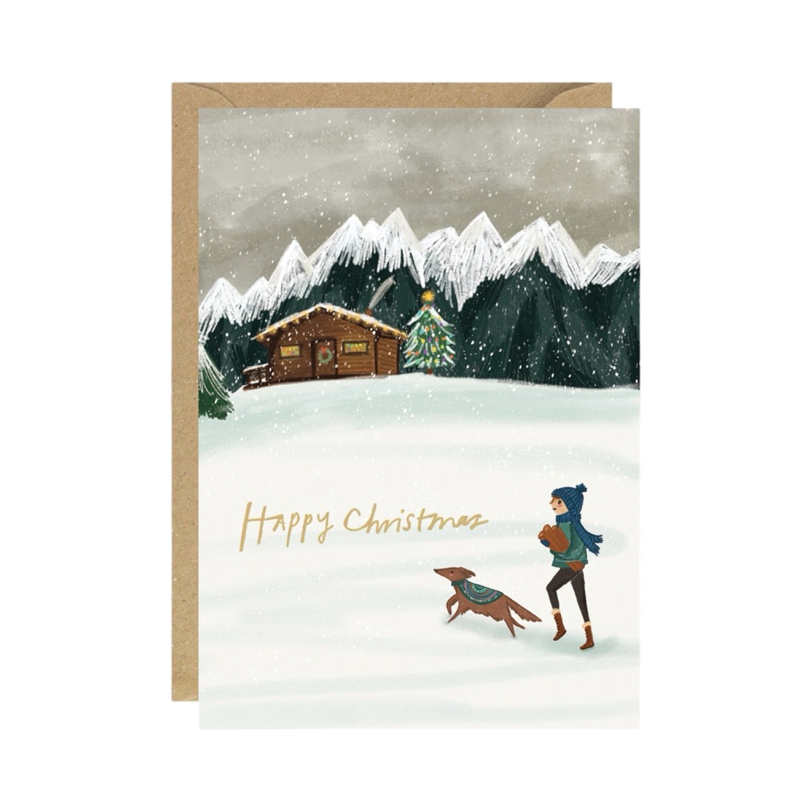 Christmas card featuring a wooden cabin amongst snowy mountains, with a person and their dog returning with firewood.
