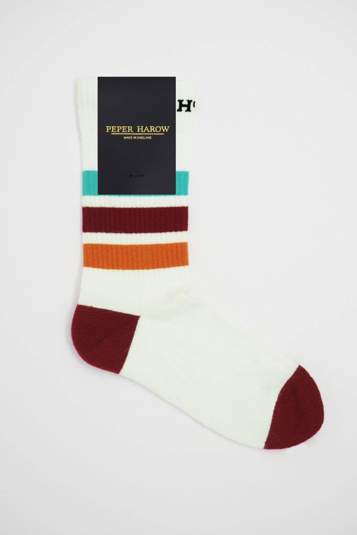 A single crew sock from Peper Harrow, featuring a cream base with horizontal stripes in teal, burgundy, and orange, with a solid burgundy toe and heel. A black paper brand tag is attached near the top cuff.