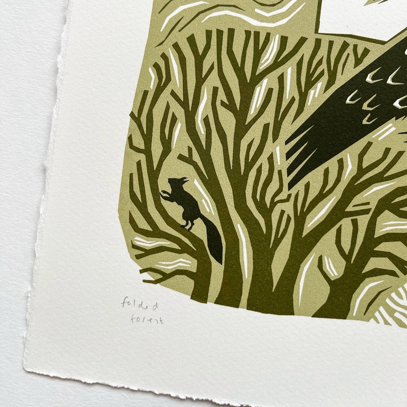 This woodland bird screen print is printed in three shades of green. It features a bird flying over its nest with trees behind, and is printed on hand-torn, thick, satin white paper.