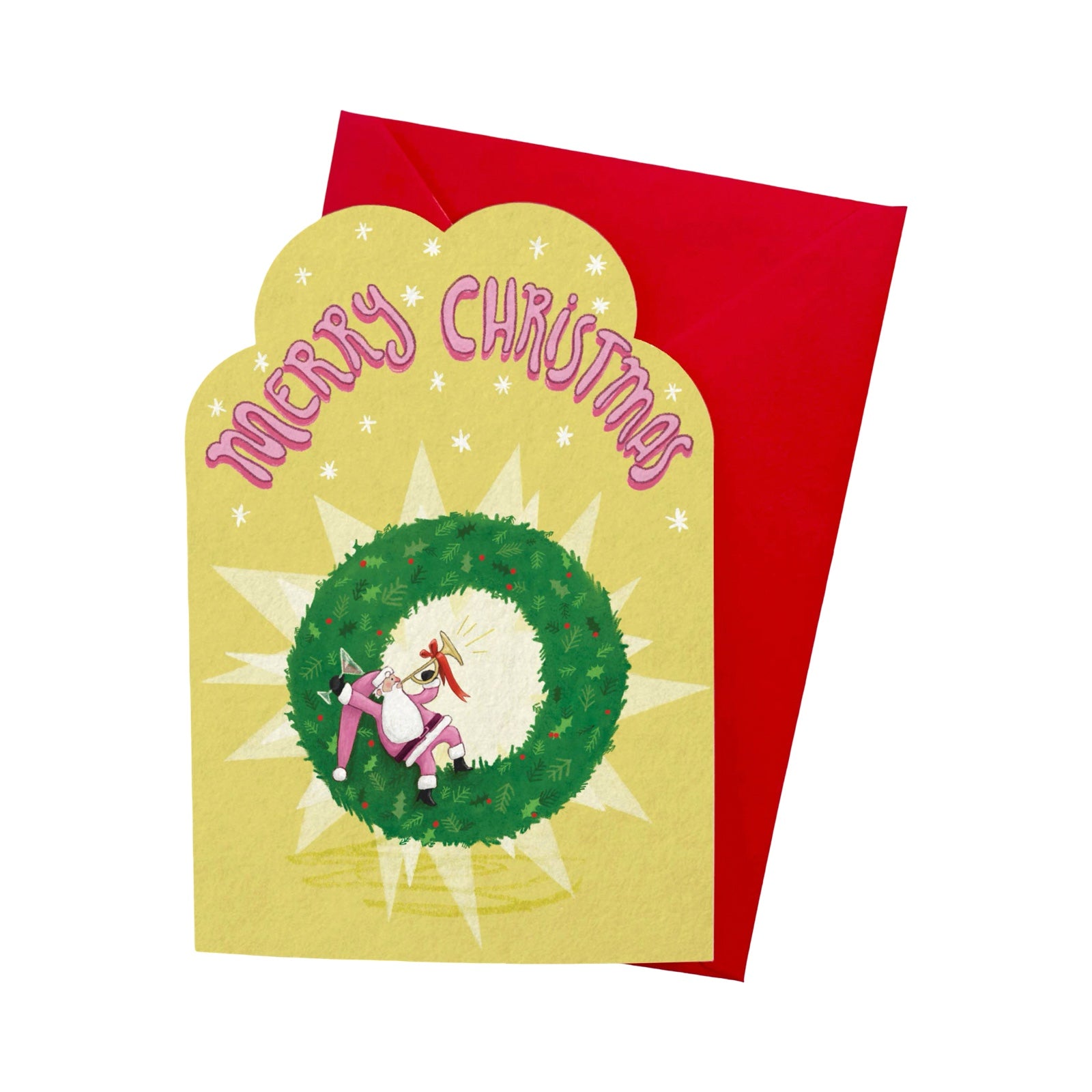 A Christmas greeting card with a scalloped yellow front featuring the words 'Merry Christmas' in pink above a green wreath illustration, shown with a red envelope behind it on a white background.