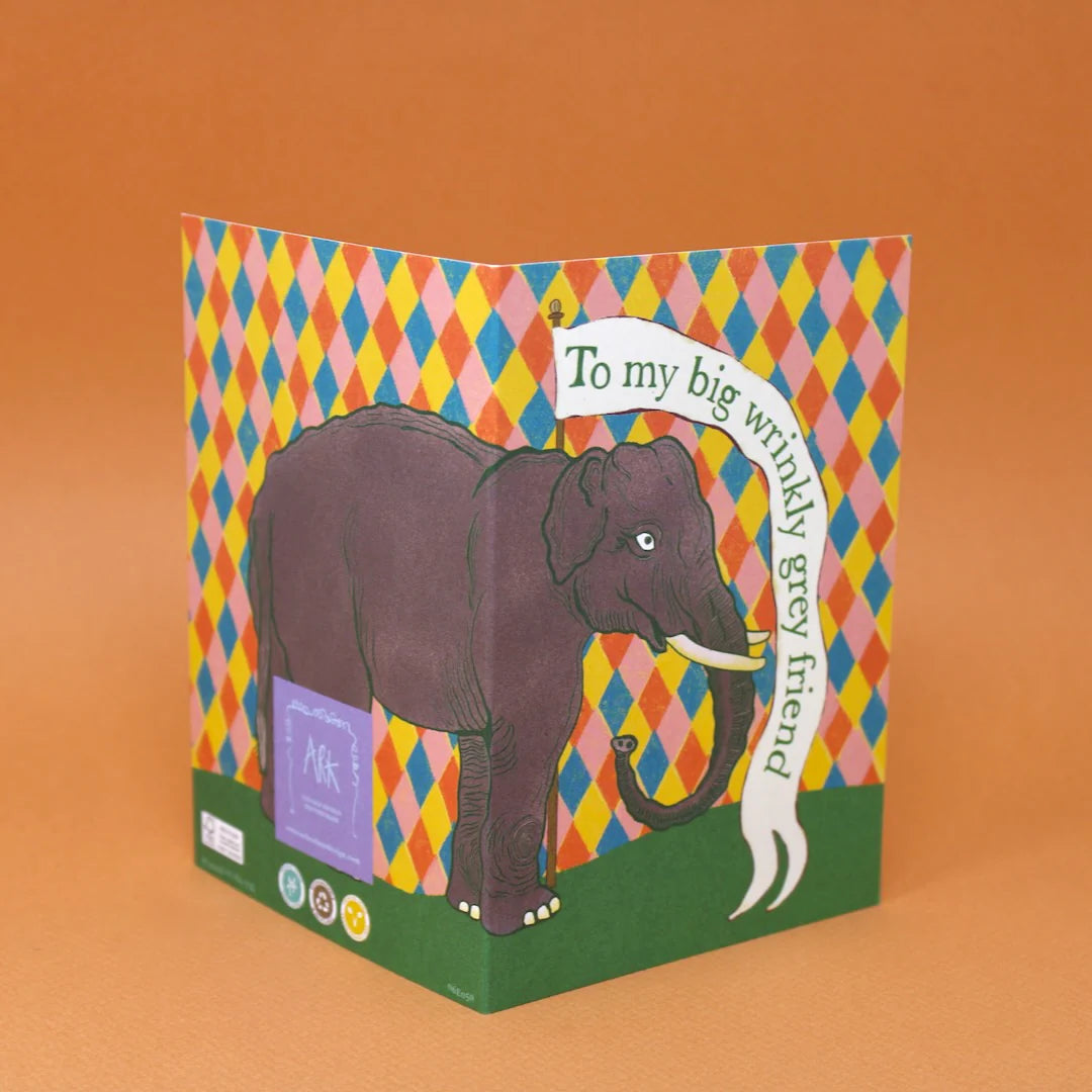 Card with an elephant illustration and colourful pattern on an orange background.