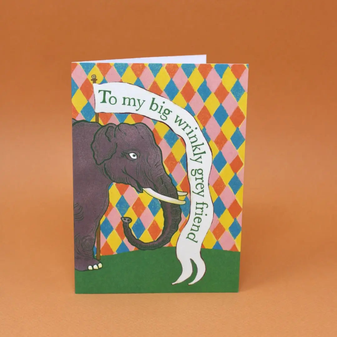 Card with an elephant illustration and colourful checkered pattern on an orange background.