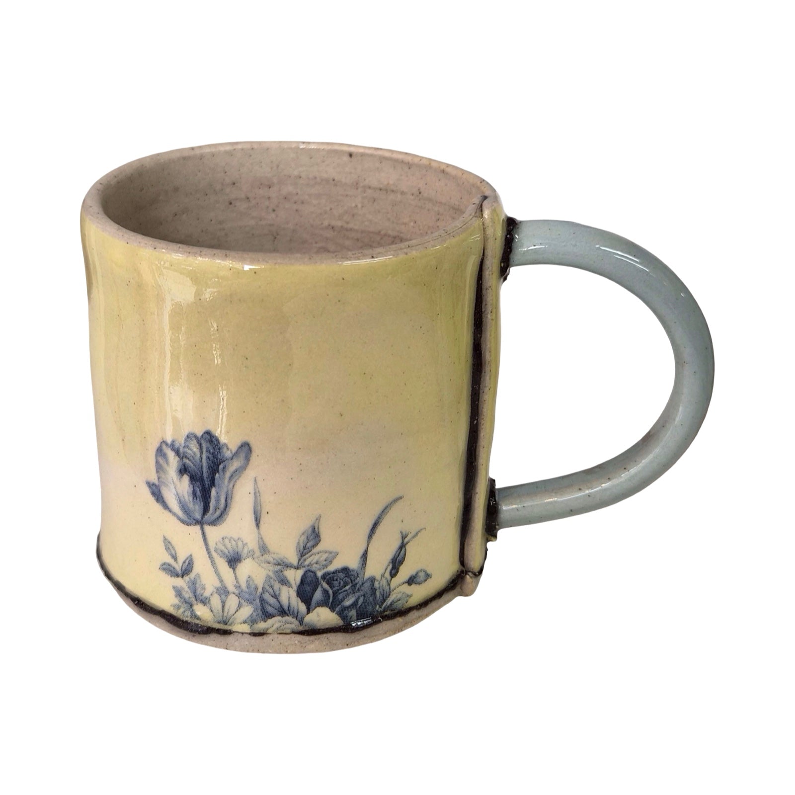 Ceramic mug with blue floral design on a yellow background.