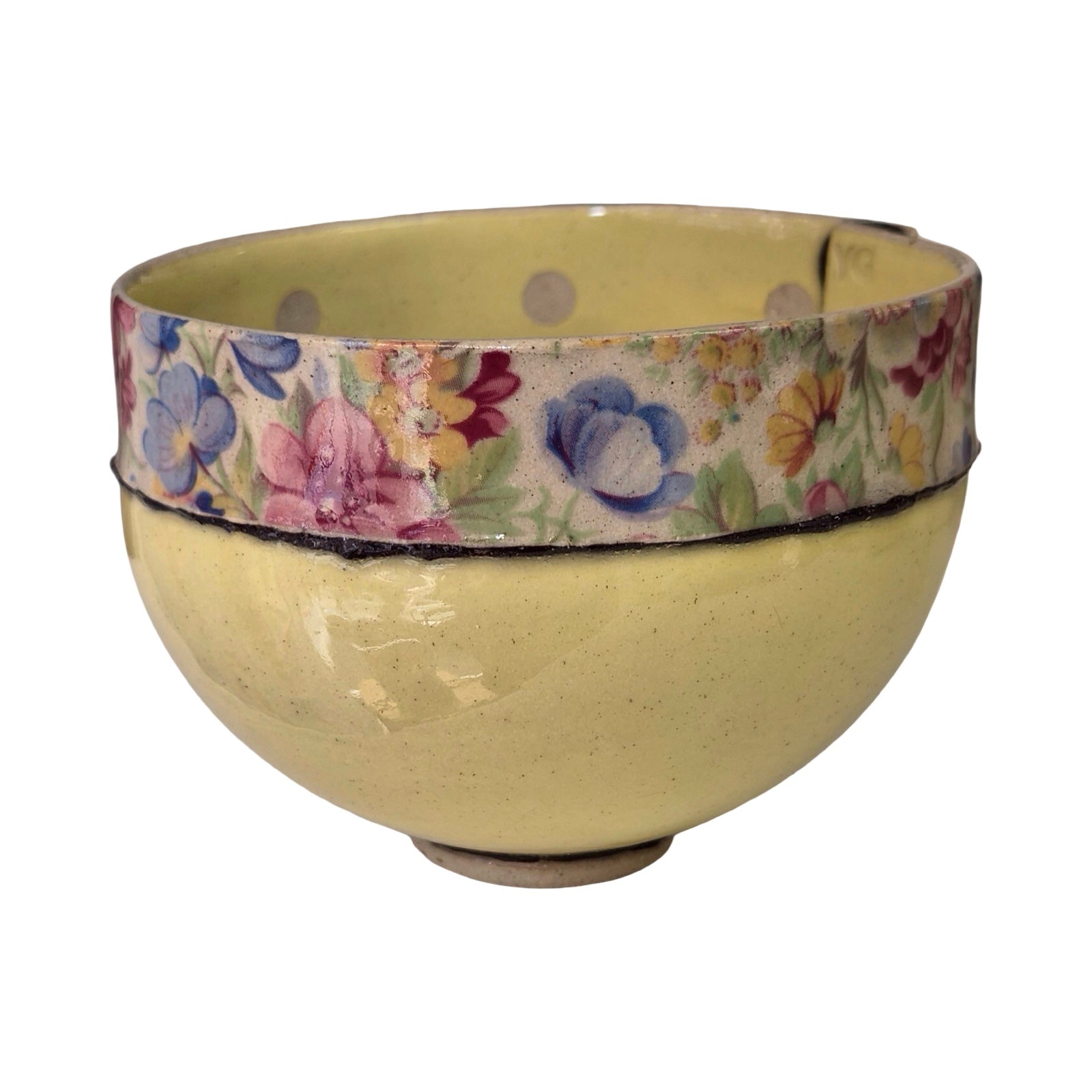 Yellow ceramic bowl with floral patterned rim on a white background.