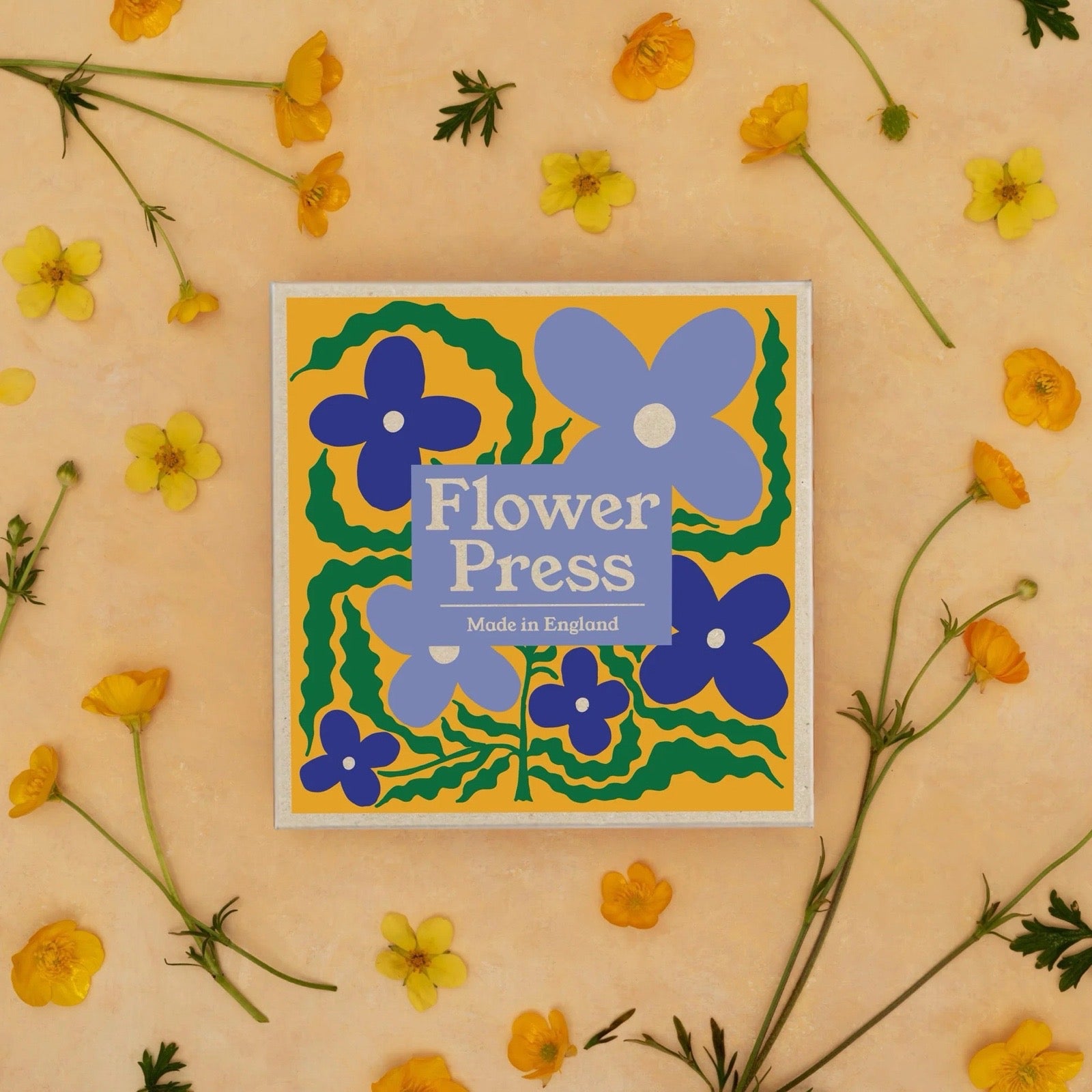 Flower Press card with blue flowers on a yellow background surrounded by yellow flowers.