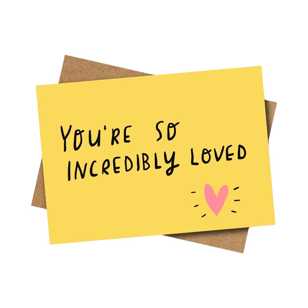 A yellow greeting card with the text 'You're So Incredibly Loved' in black and a pink heart symbol in the corner.
