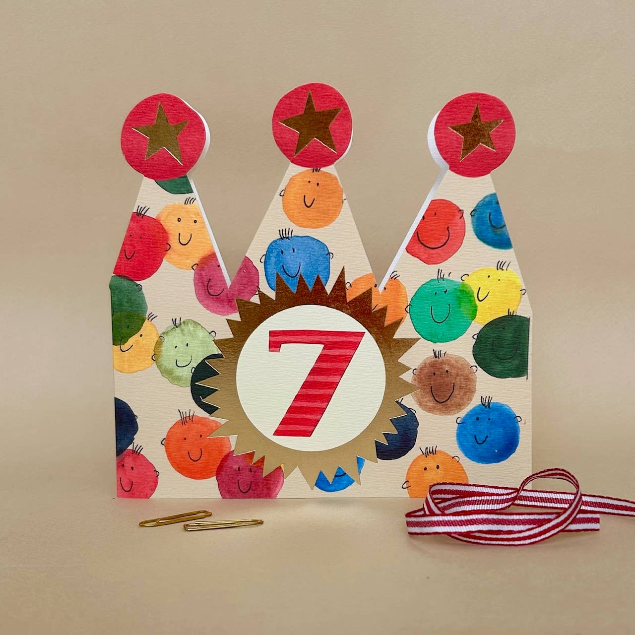 Colourful birthday card with number 7 and cartoon characters on a beige background.