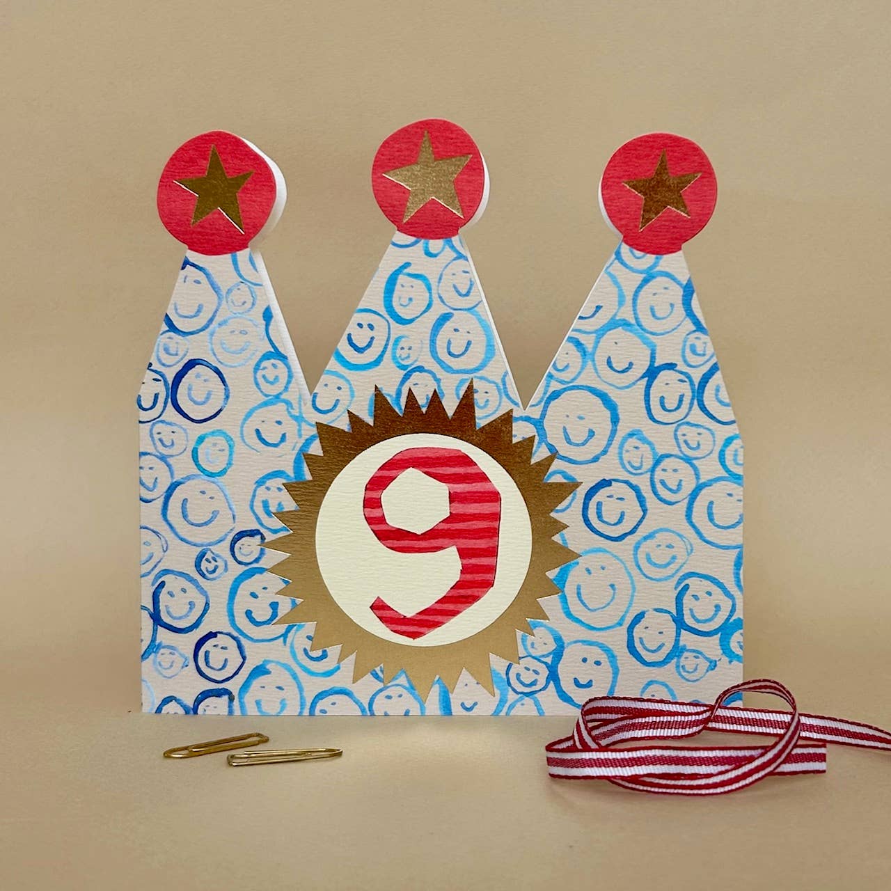 Decorative birthday crown card with number 9 on a beige background.