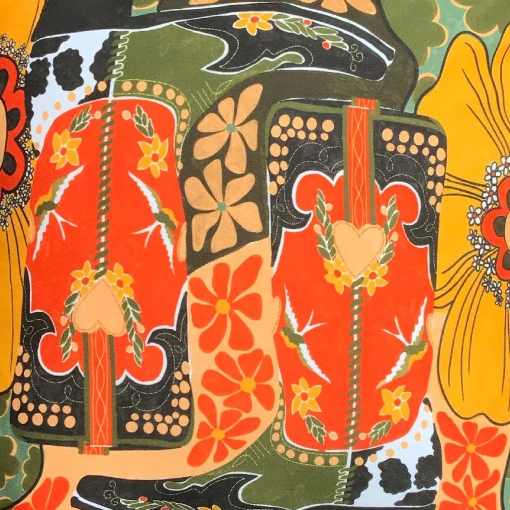 A cushion cover featuring a pair of cowboy boots surrounded by flowers, all in retro tones.