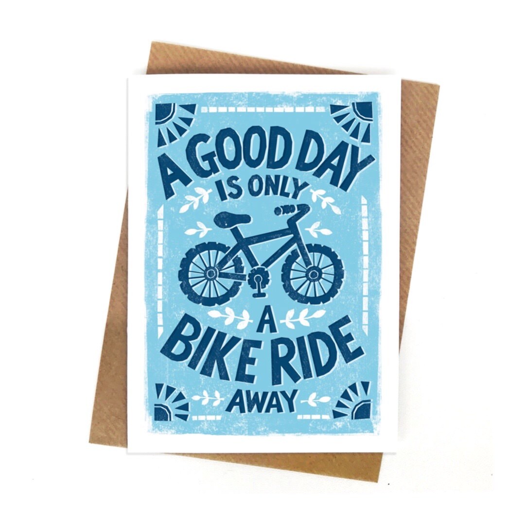 Cycling card featuring a illustration of a bicycle and the text a good day is only a bike ride away, all in blue against a pale blue background.