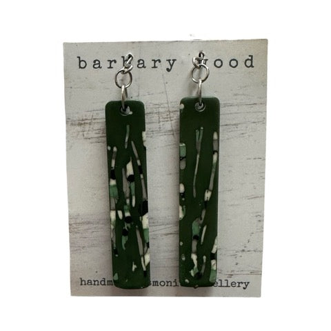 A pair of long rectangular earrings in green with an black, white and grey abstract design and stainless steel earring posts.