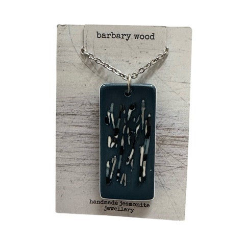 A blur rectangular pendant necklace with a black and white abstract design on a silver chain