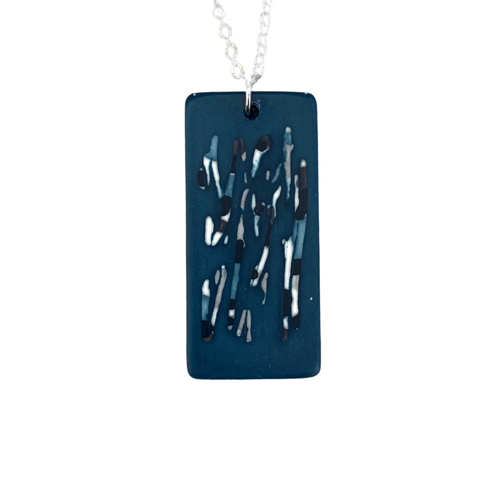 A blur rectangular pendant necklace with a black and white abstract design on a silver chain