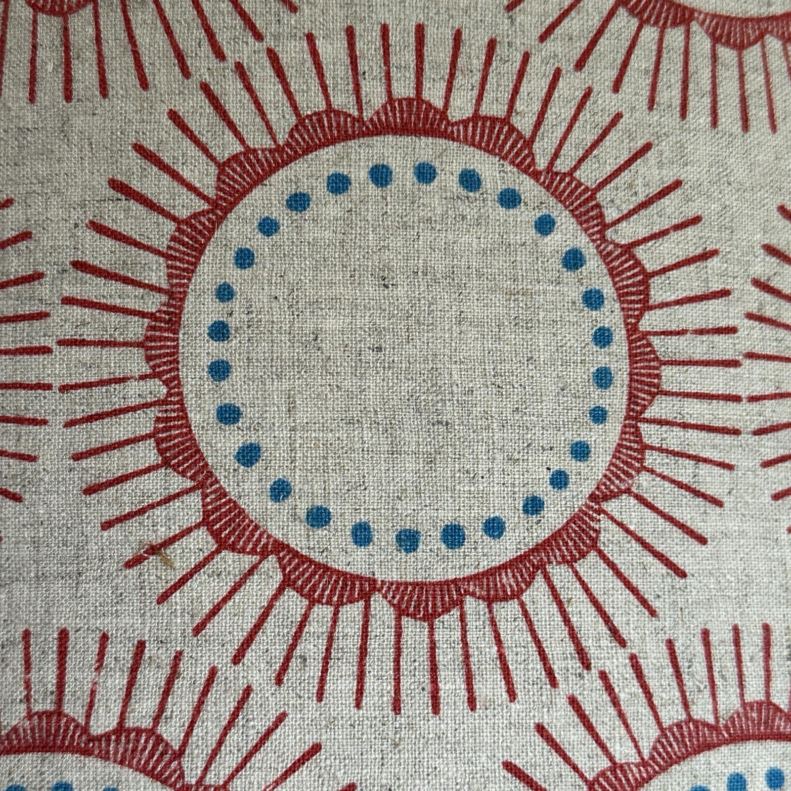 Cream fabric with red abstract flowers and blue spots.