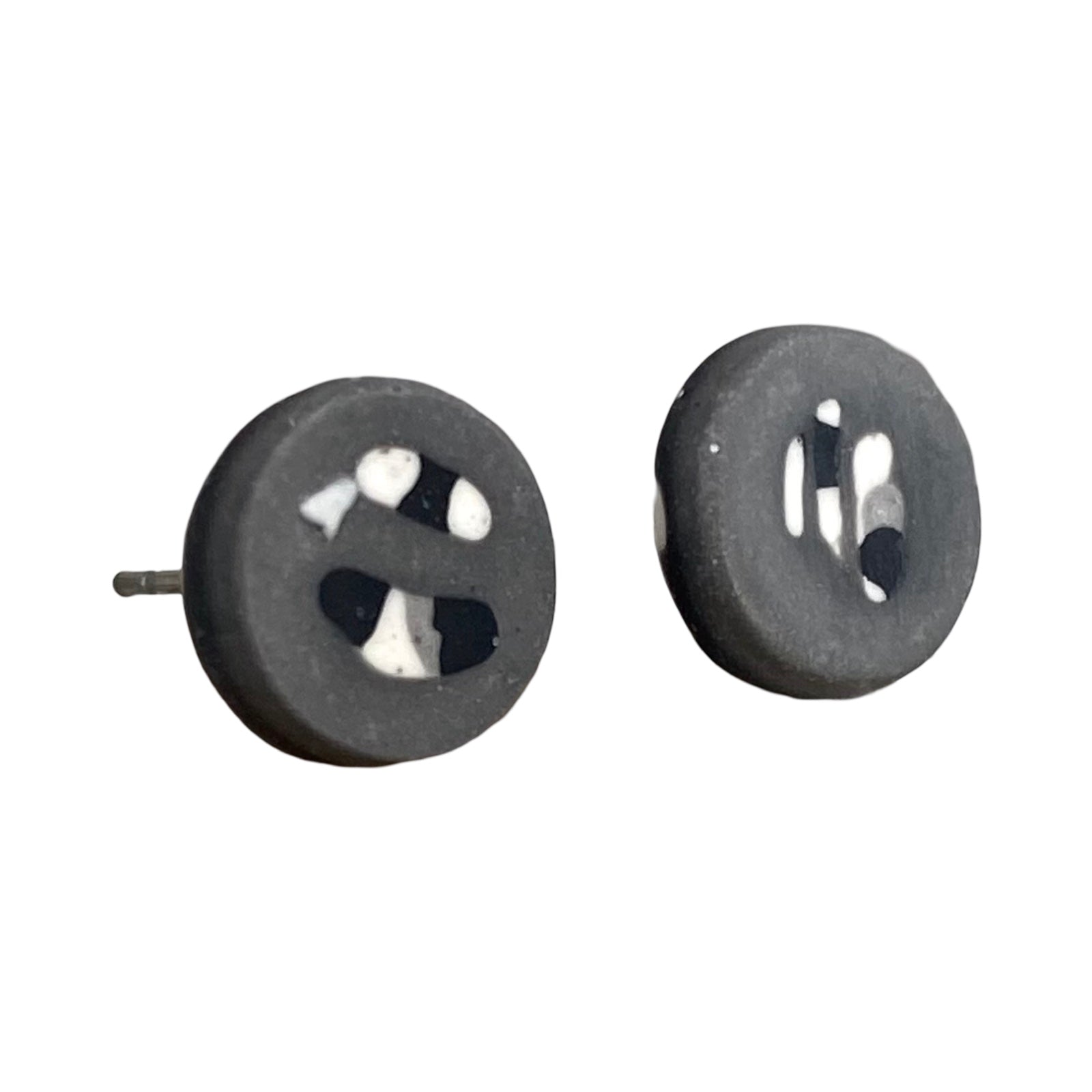 Grey round stud earrings with a black and white abstract pattern.